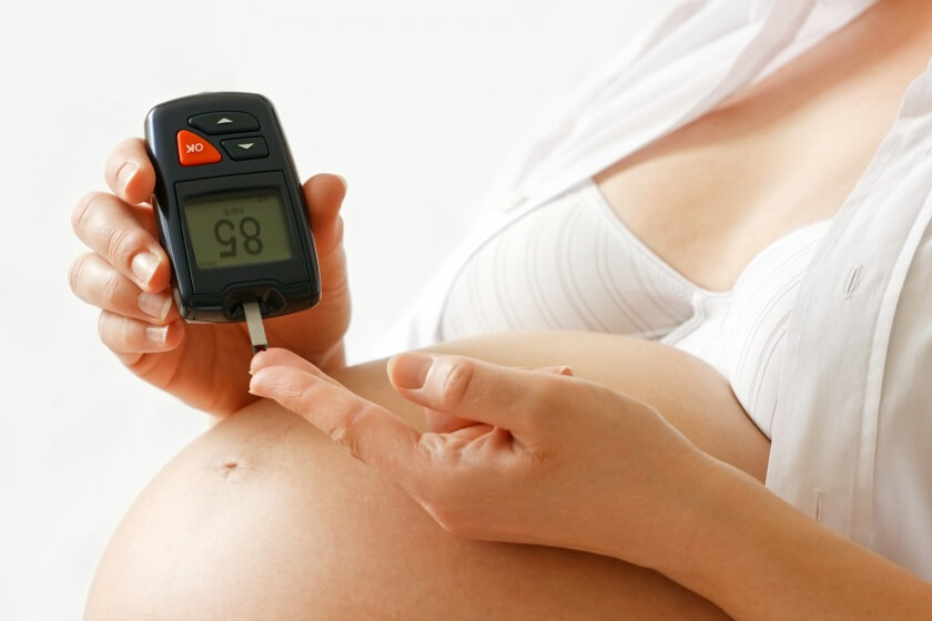 Diabetes in der Schwangerschaft Schwangere mit Schwangerschaftsdiabetes misst Blutzucker
