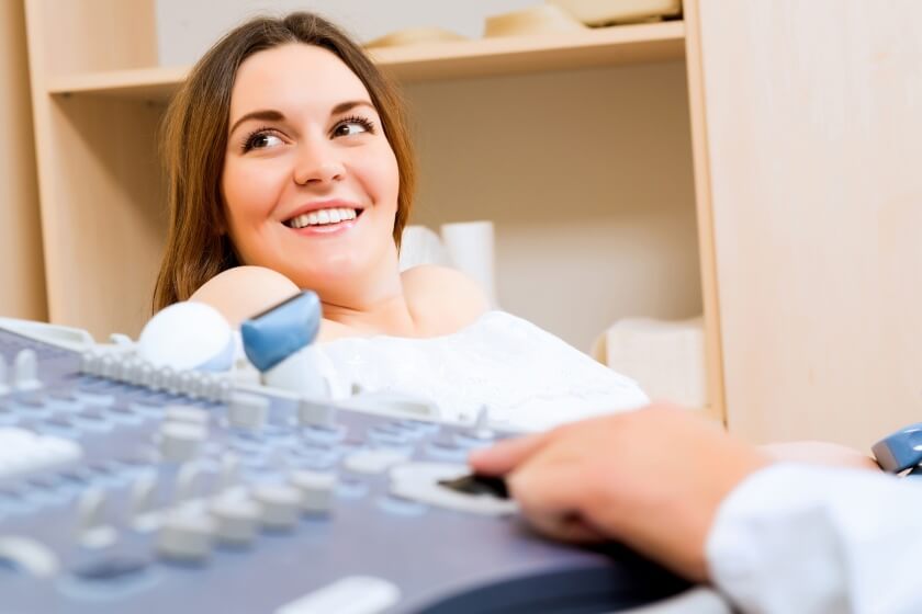 Frau in der Frühschwangerschaft beim Ultraschall Frühschwangere beim Ultraschall