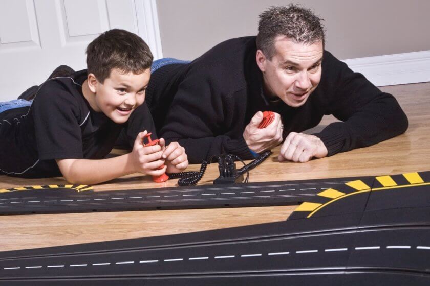 Spielzeug Autorennbahn Vater & Sohn spielen mit Carrera Bahn