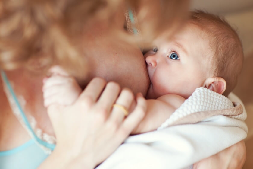Baby trinkt Muttermilch über die Brust seiner Mama