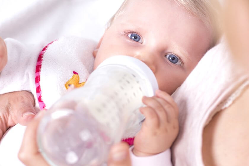 Baby trinkt aufgewärmte Muttermilch aus der Flasche