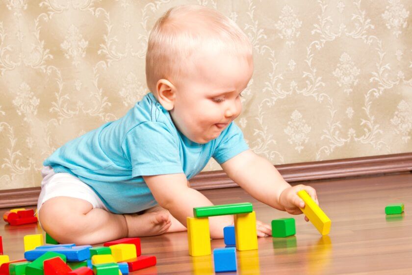 Baby spielt mit Bauklötze im Kinderzimmer