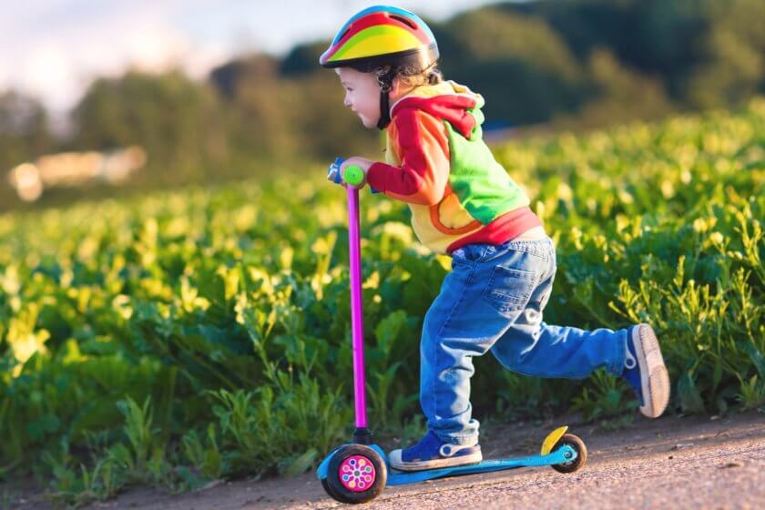 Kleinkind fährt mit Kinderroller mit drei Räder