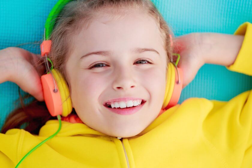 Mädchen hört über Kinder Musikbox mit Kopfhöreranschluss ein Hörspiel