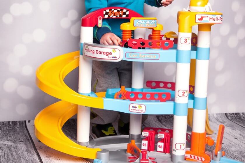 Kind spielt mit Spielzeug Parkhaus für Spielzeugautos